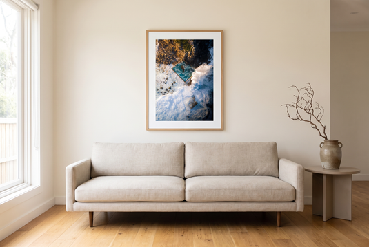 Sydney rockpool print framed above a sofa in a gallery-modern living room